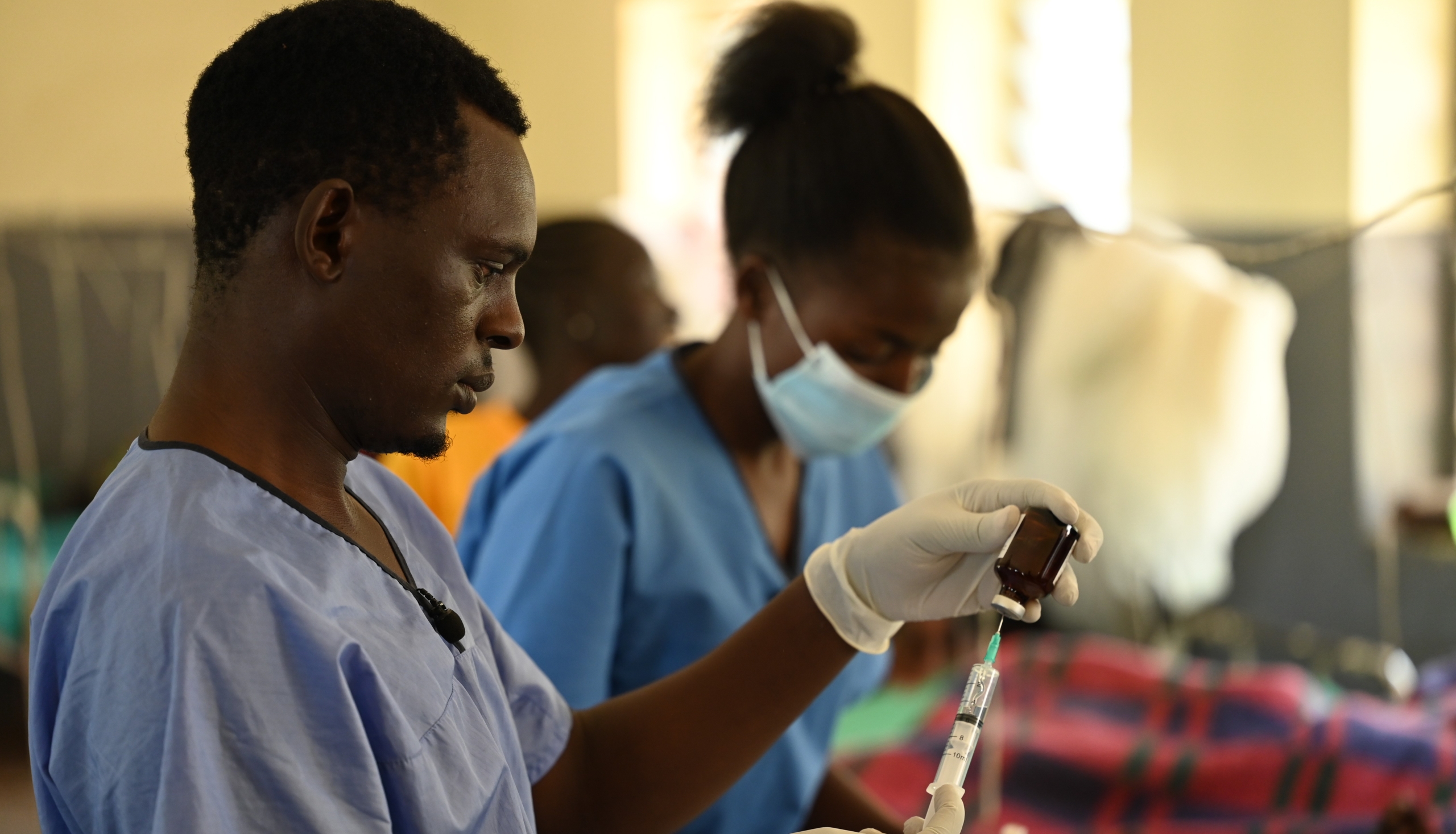 Healthcare providers prepare medicine at a health clinic.